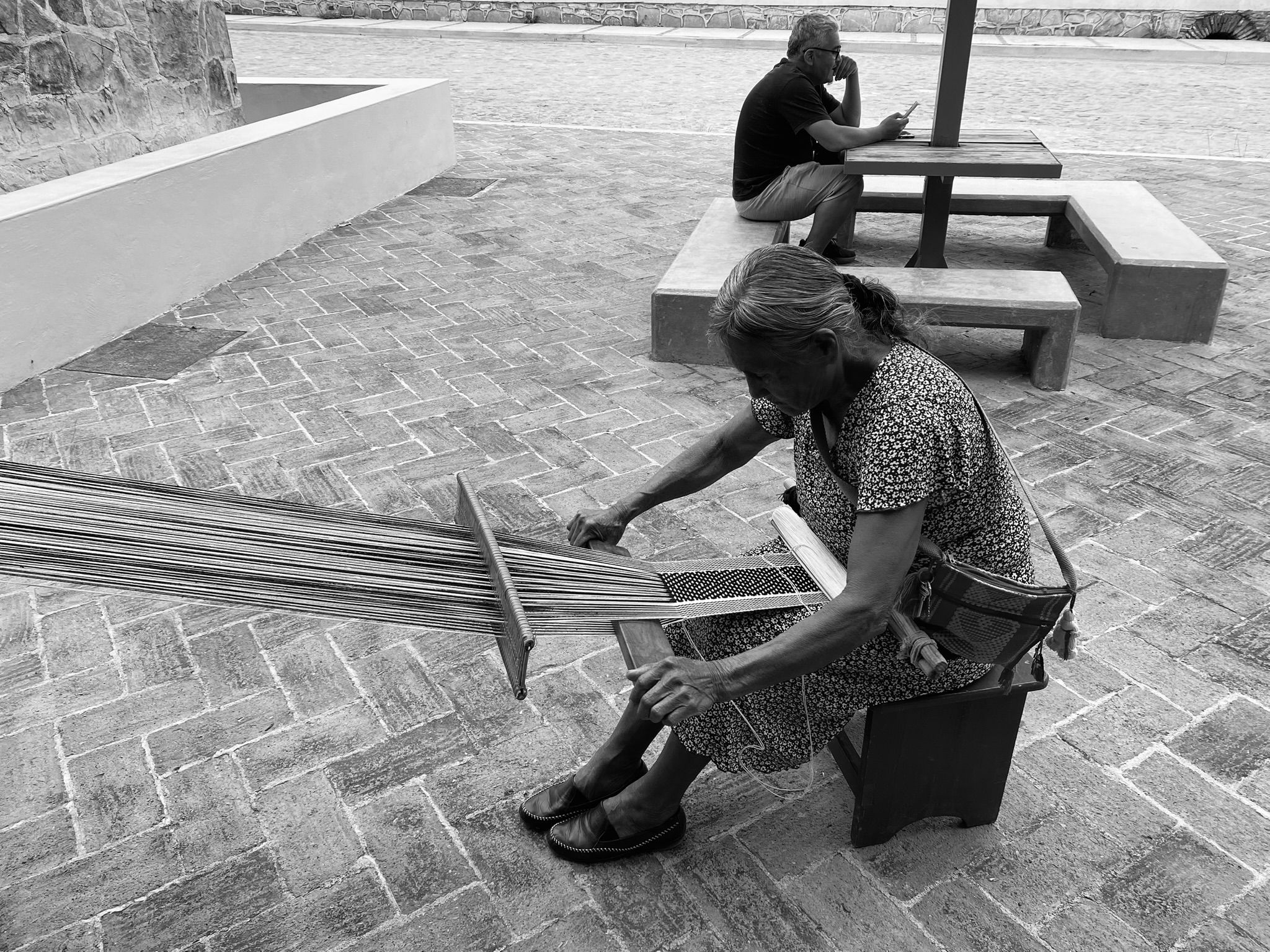 An artisan weaving on a traditional backstrap loom